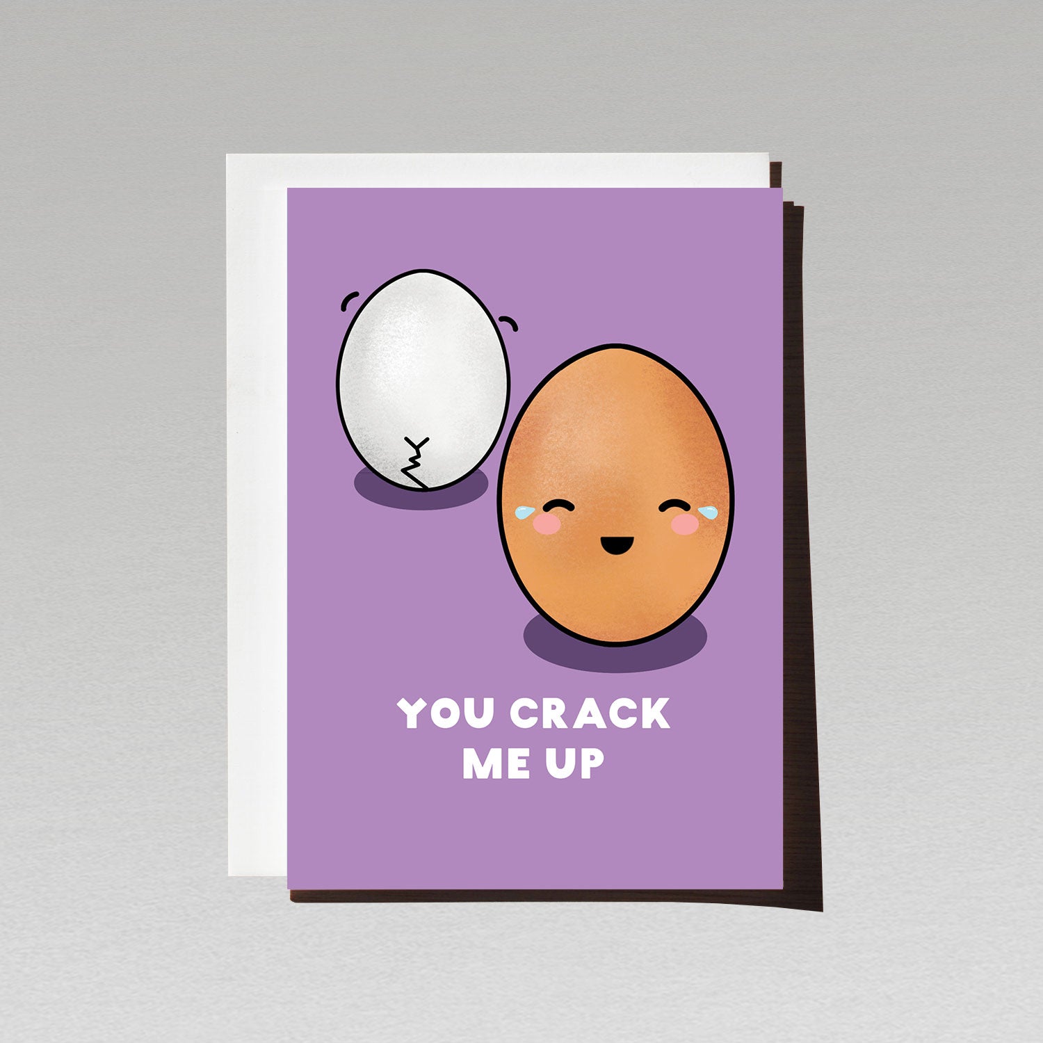 Greeting card with two cute egg characters one walking away with crack in its shell like a bum crack the other laughing facing forward on purple background with text You Crack me up